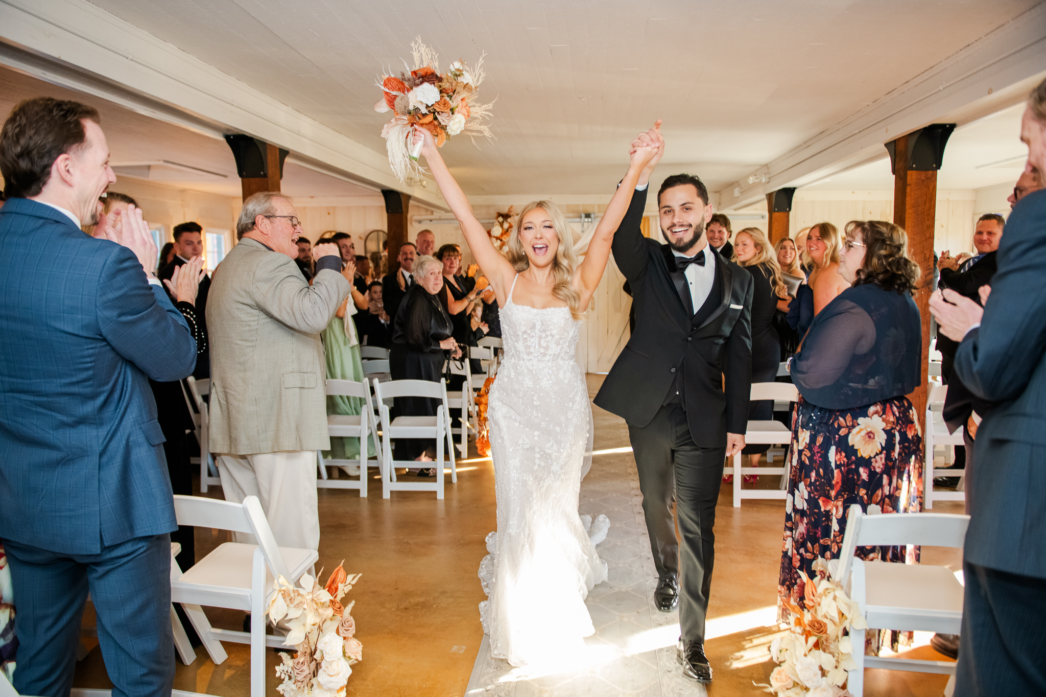 Bride and groom celebrating as they walk down the aisle of their Bluebird Manor ceremony