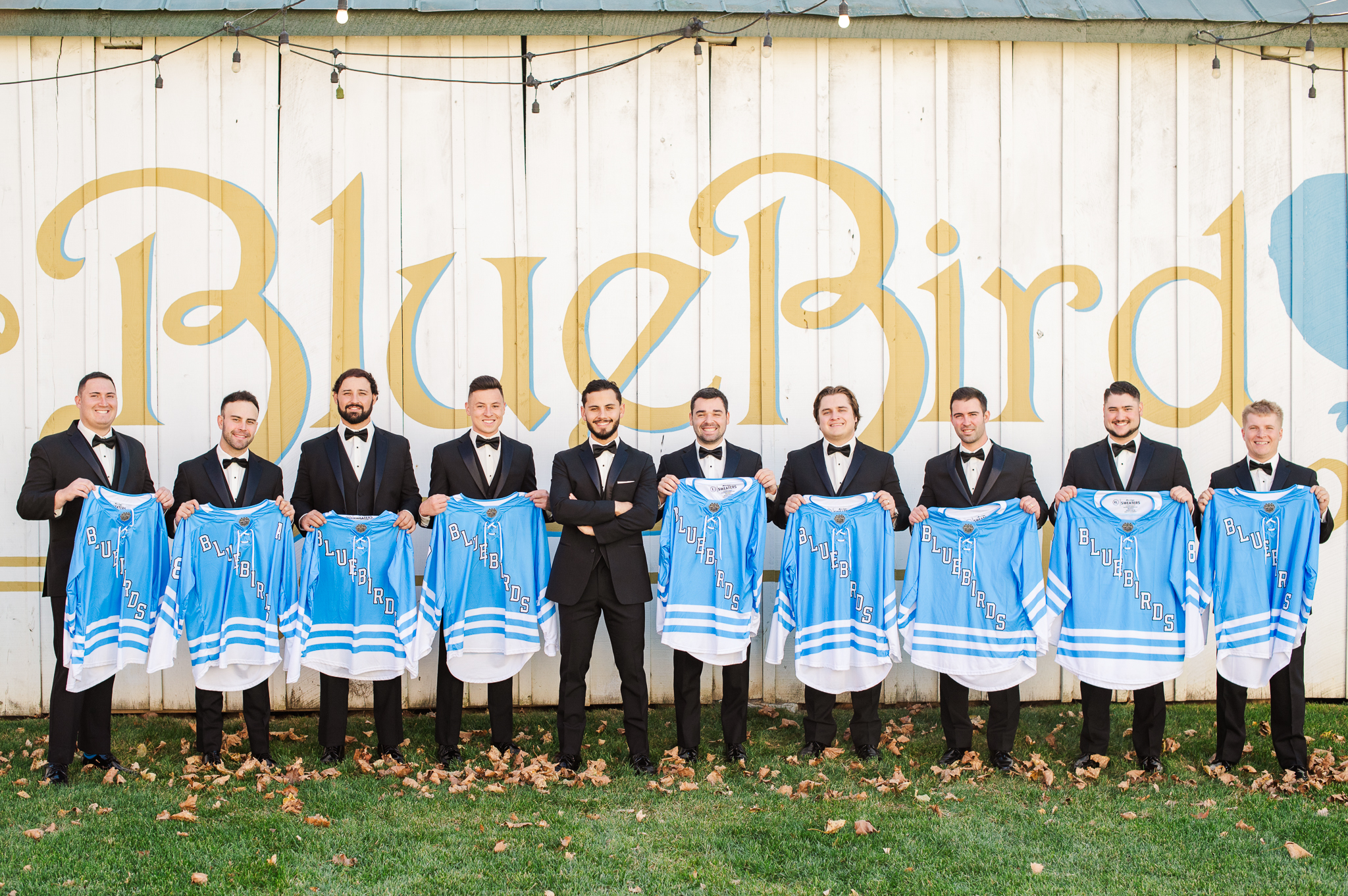 Groomsmen holding custom Bluebird Manor jerseys in Frederick Maryland