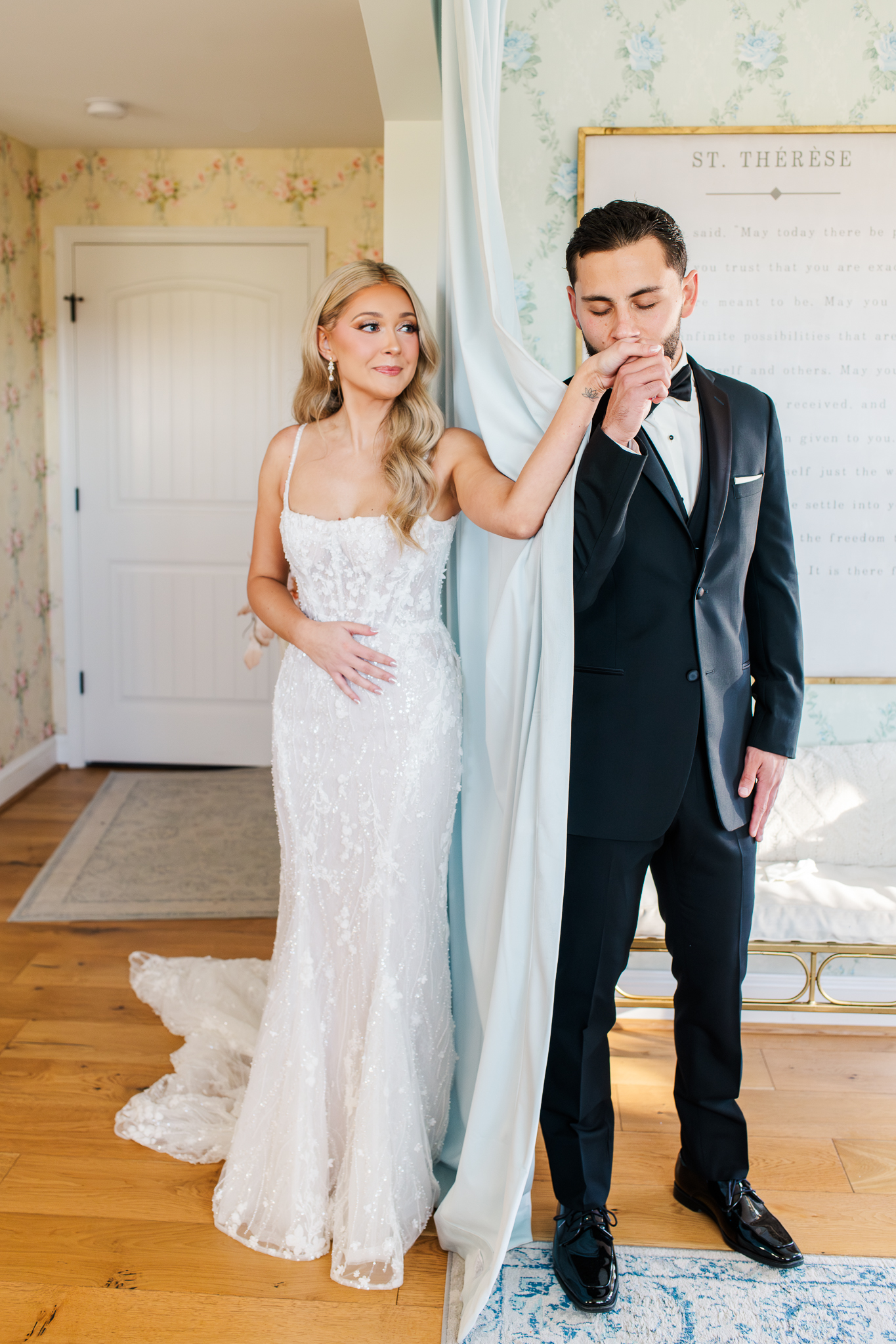 Groom kissing his bride's hand during a romantic first touch at Bluebird Manor