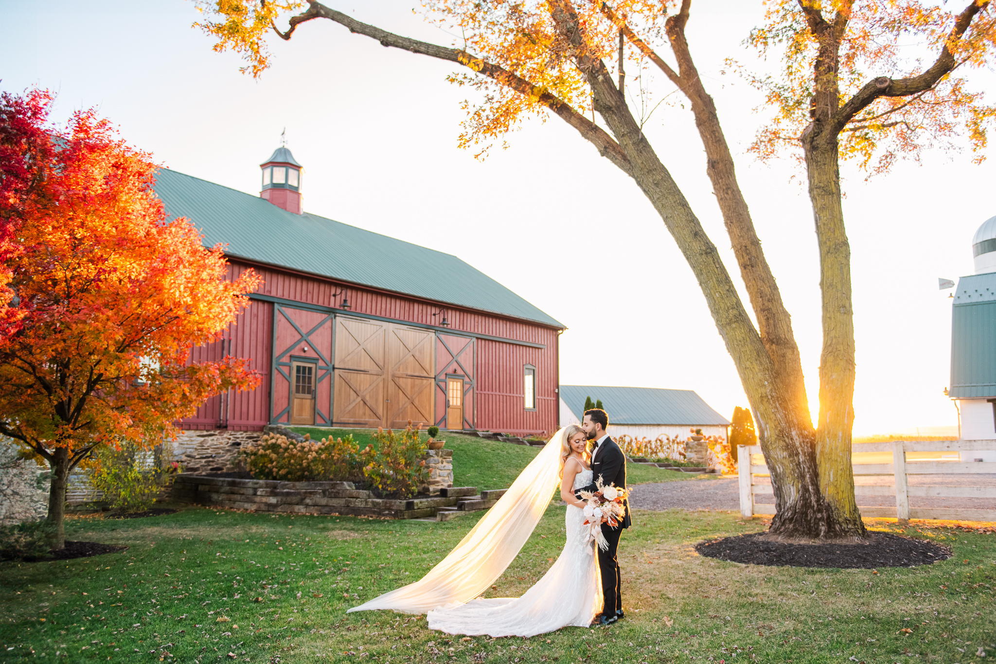 Romantic portrait of Hailey and Jake at their Bluebird Manor wedding in Maryland, in front of the red barn