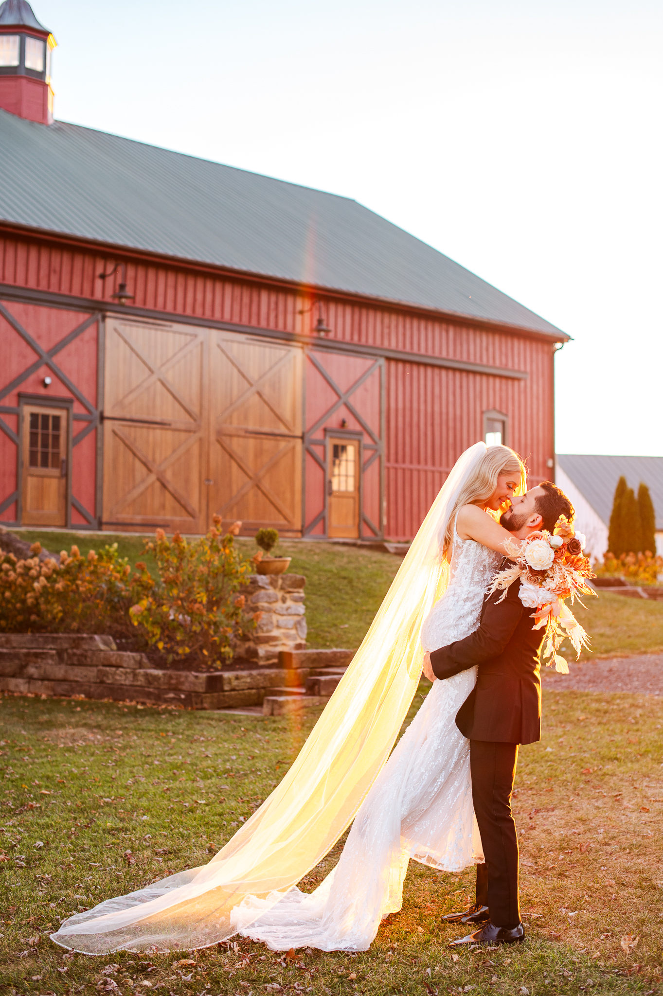 Romantic portrait of Hailey and Jake at their Bluebird Manor wedding in Maryland, in front of the red barn