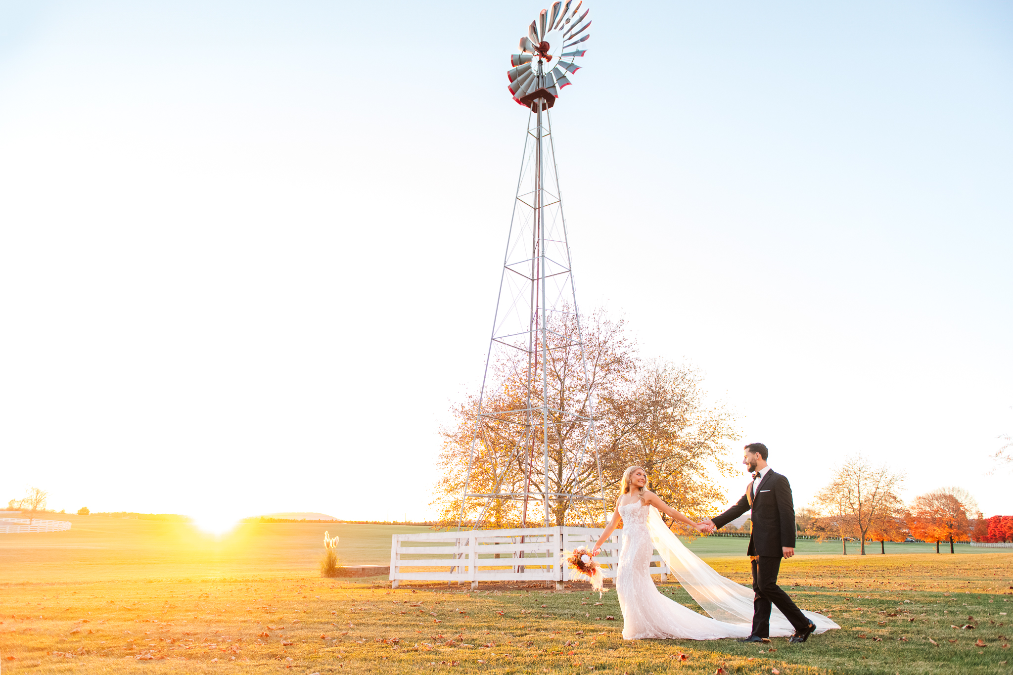 Bride and groom portraits walking in front of the windmill at Bluebird Manor in Maryland