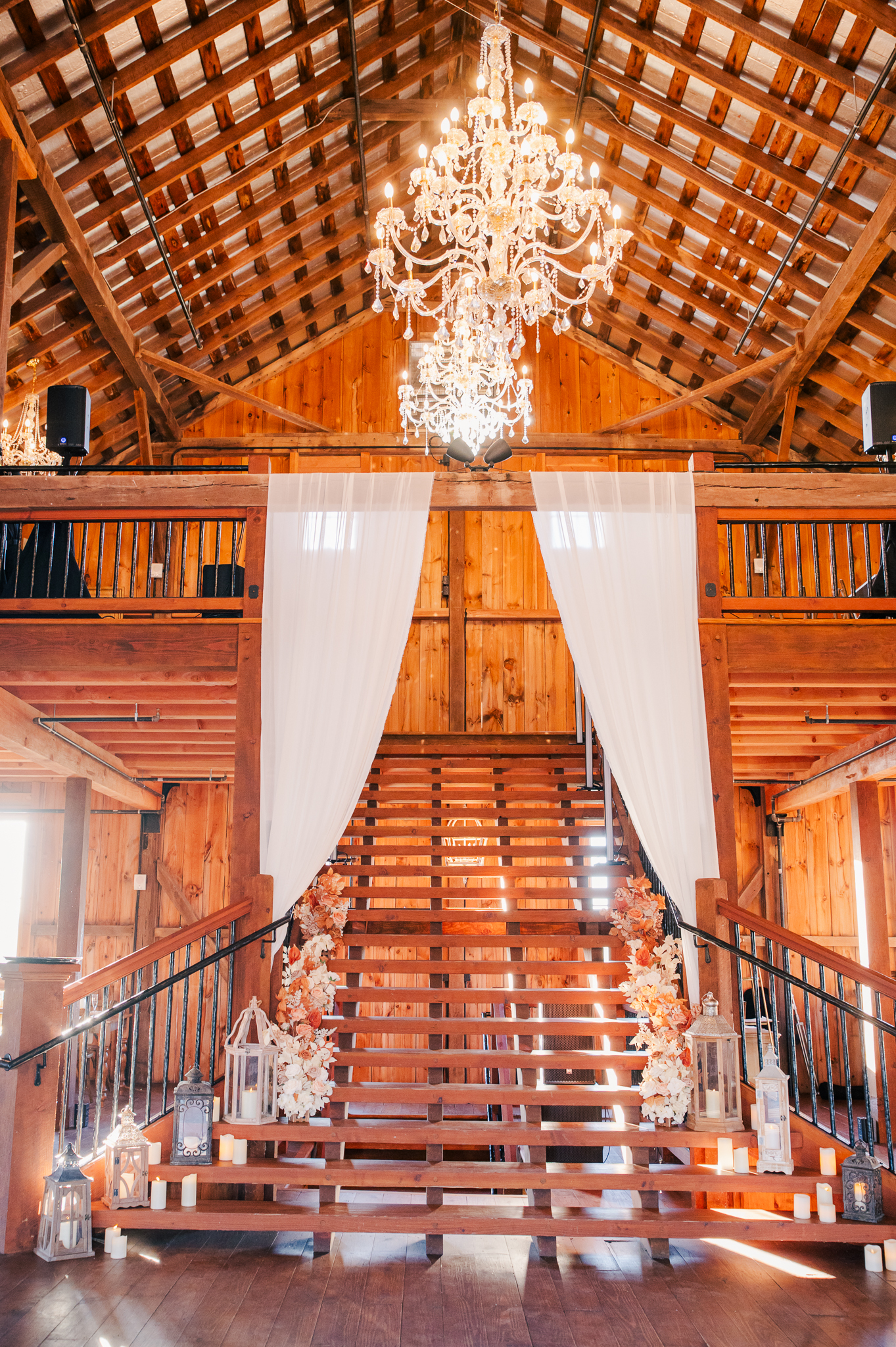 The gorgeous red barn reception hall featuring their chandeliers