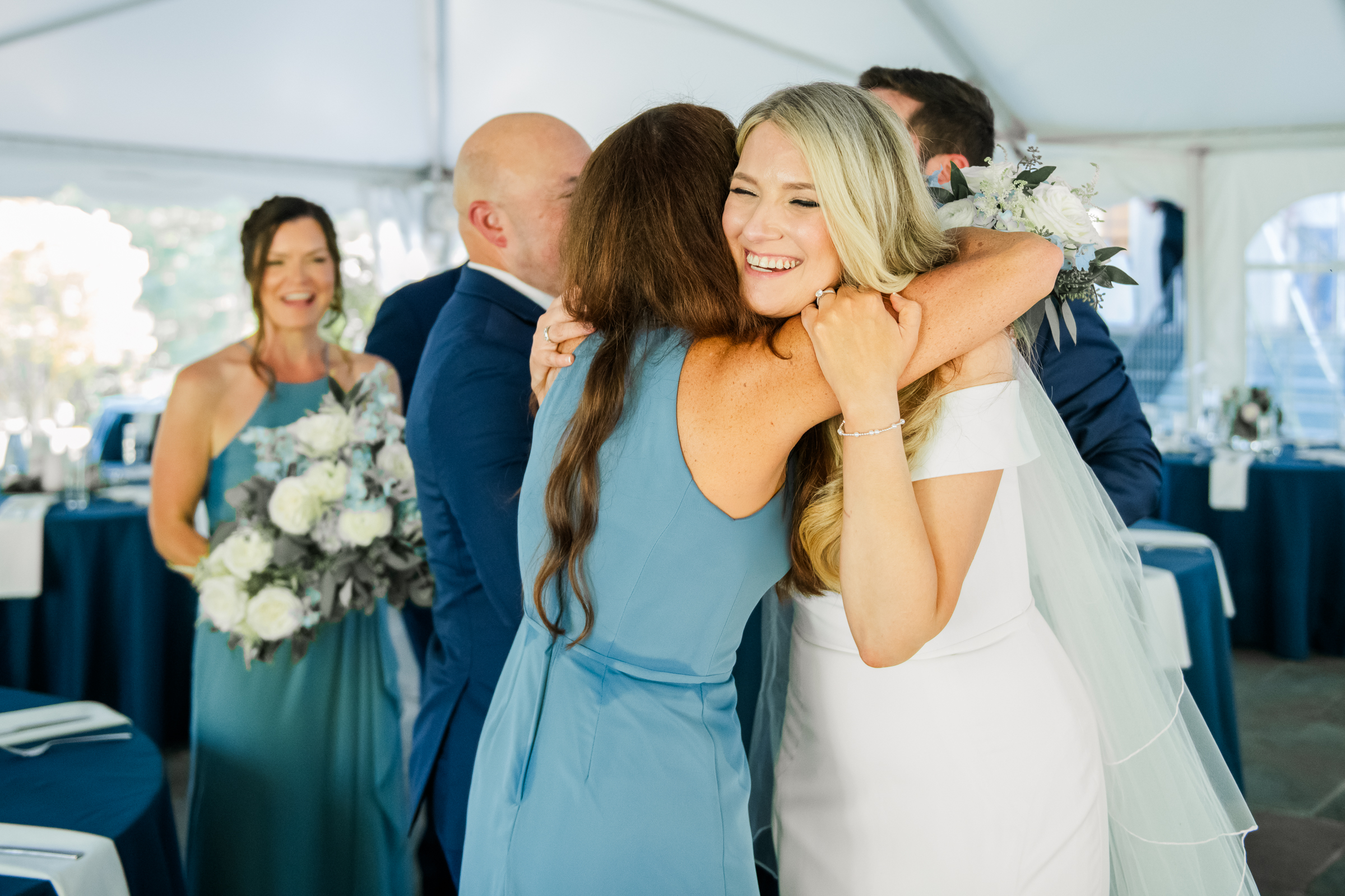 A sweet candid moment of a bride hugging her bridesmaid after the ceremony