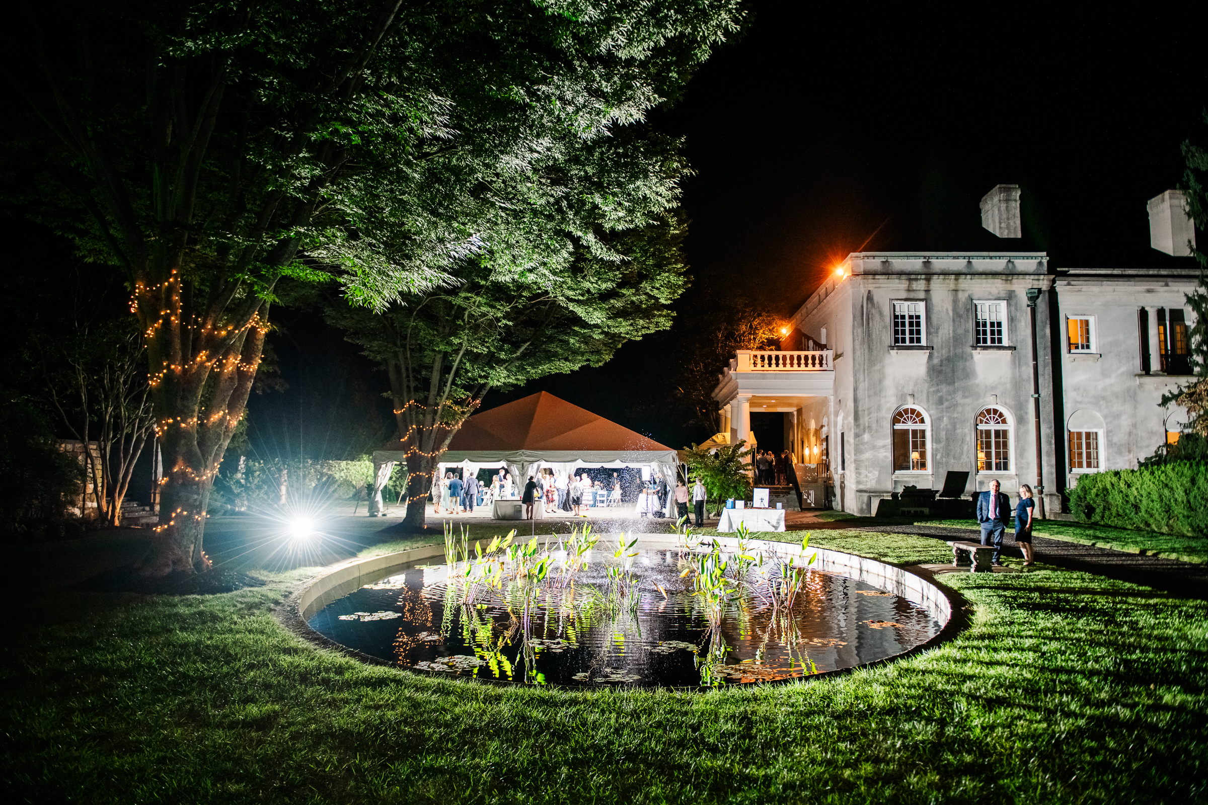 A wide-angle night portrait of aluxury outdoor wedding reception at the historic Strong Mansion in Frederick, Maryland, photographed by Mary Sarah Photography.