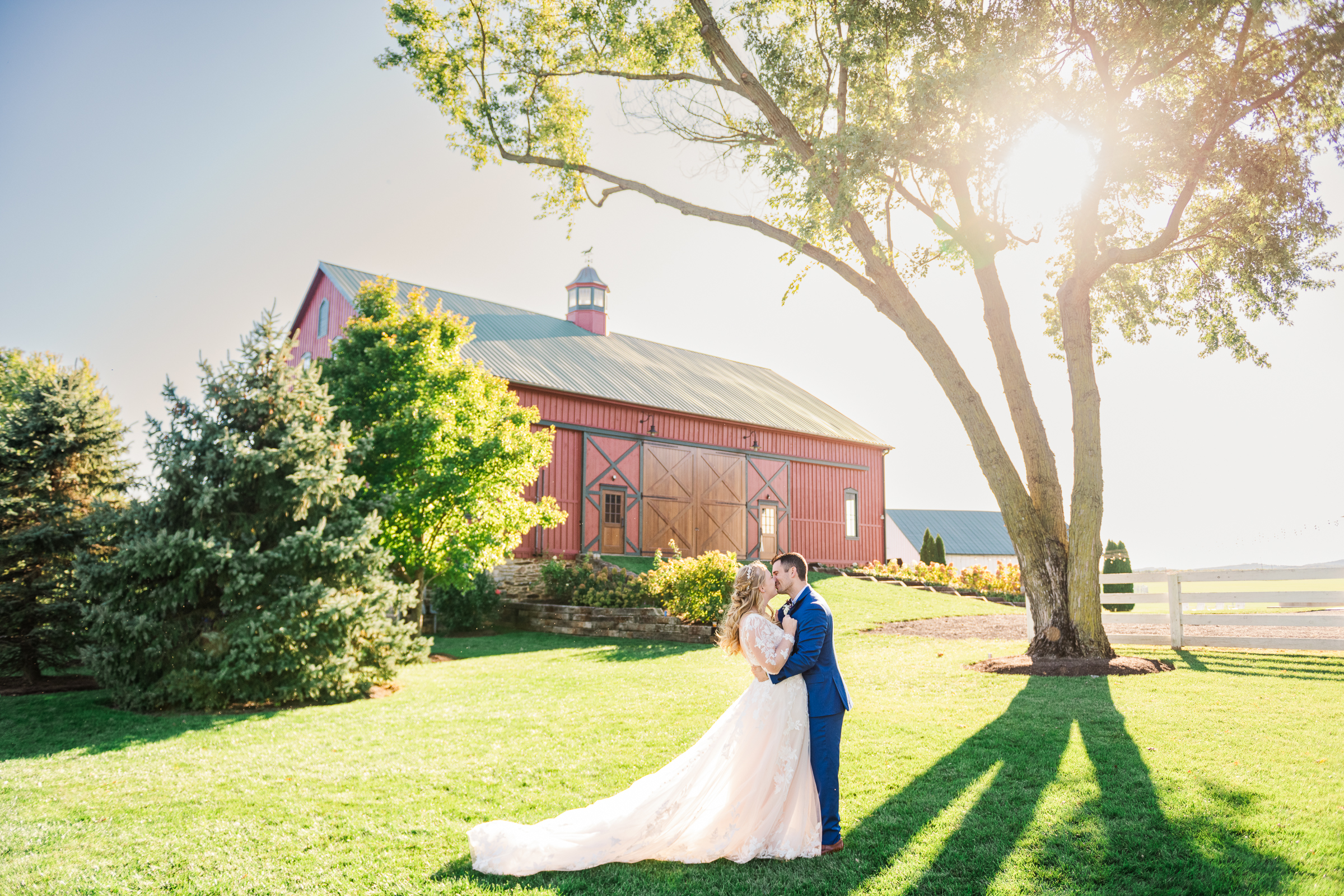 Bride and groom portrait at Bluebird Manor with red barn and sunset light in Frederick Maryland