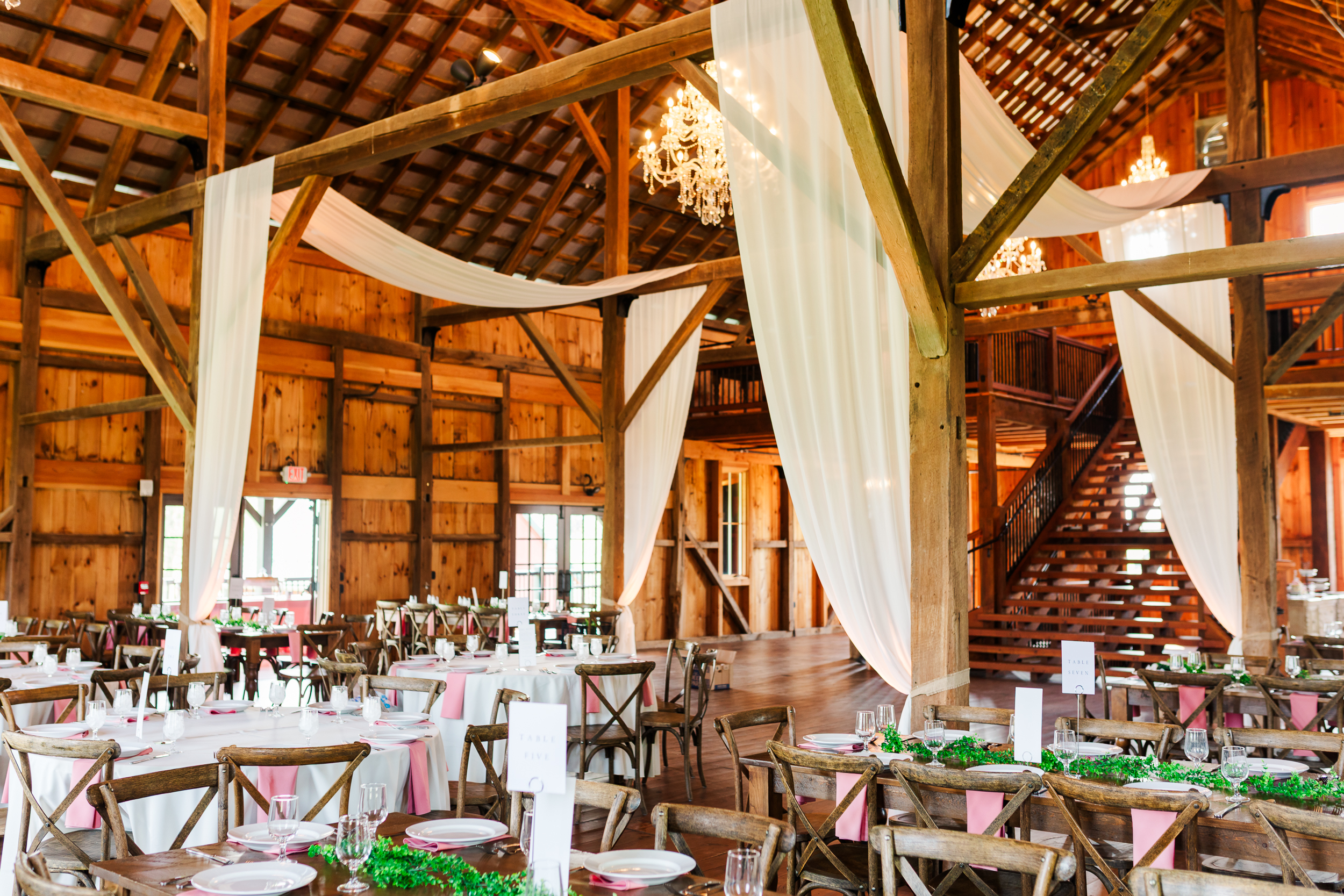 Elegant summer wedding reception at Bluebird Manor's red barn in Maryland