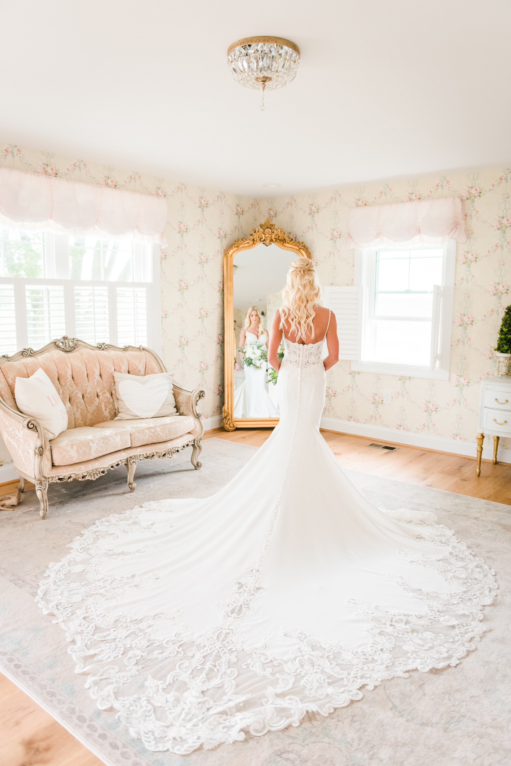 Bride standing in front of ornate mirror inside The Nest at Bluebird Manor