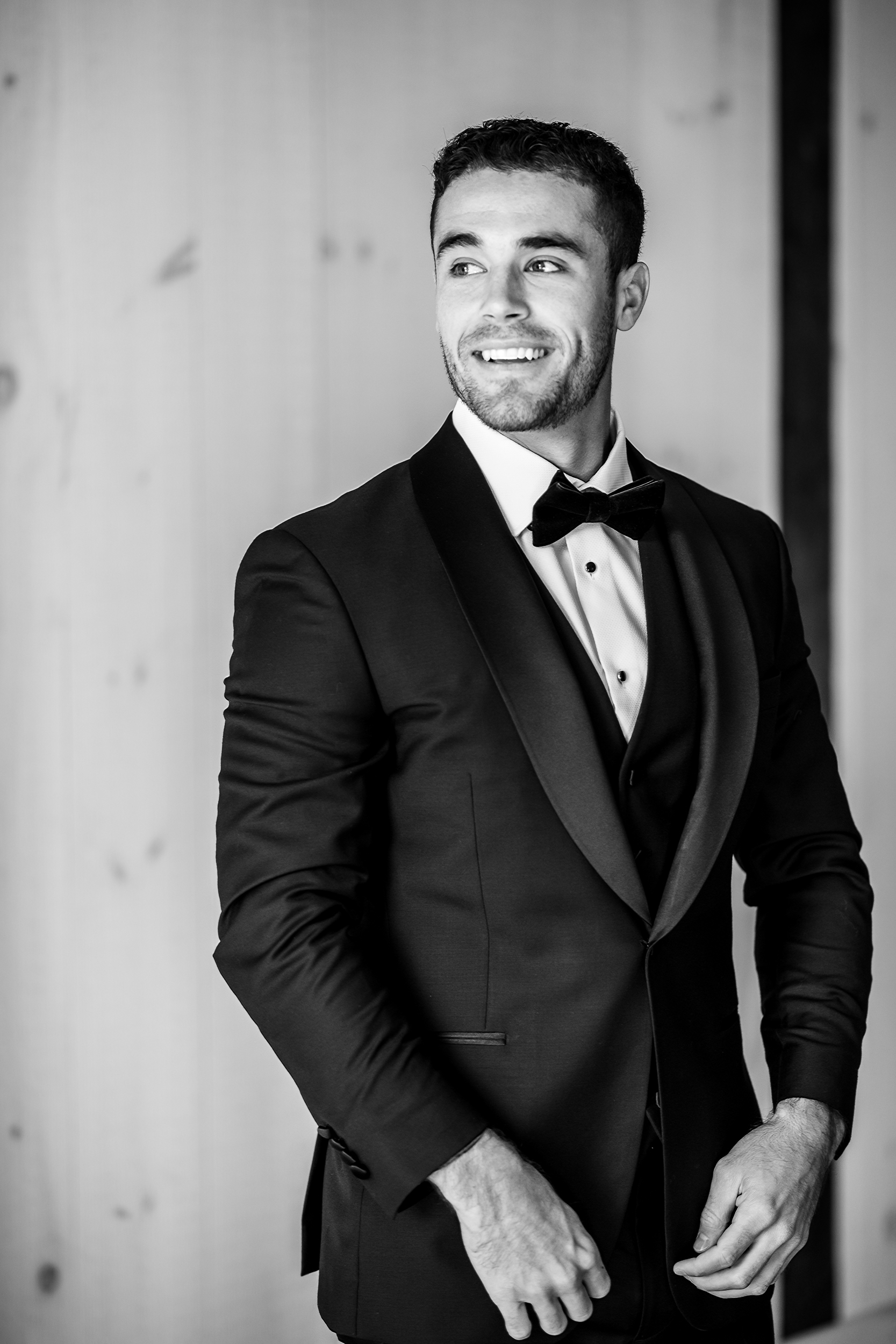 Black and white portrait of groom in tuxedo at Bluebird Manor