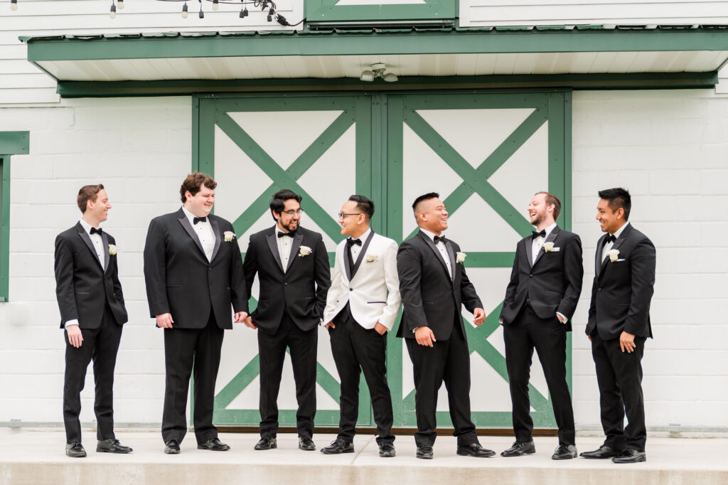 Groomsmen standing in front of green barn doors 