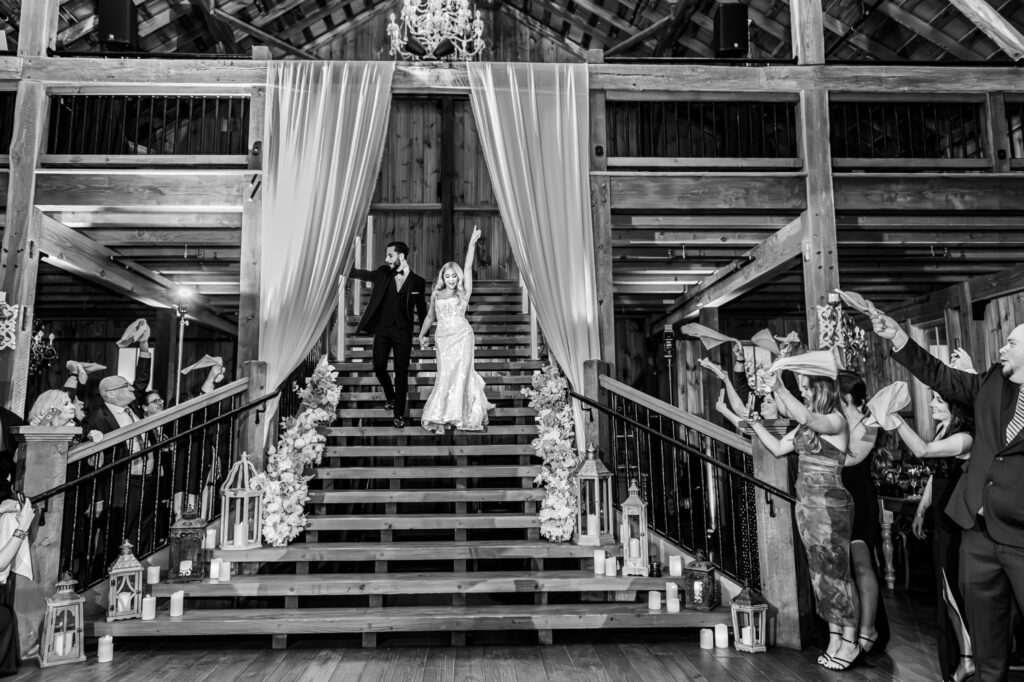 Couple making their grand entrance down the staircase at Bluebird Manor