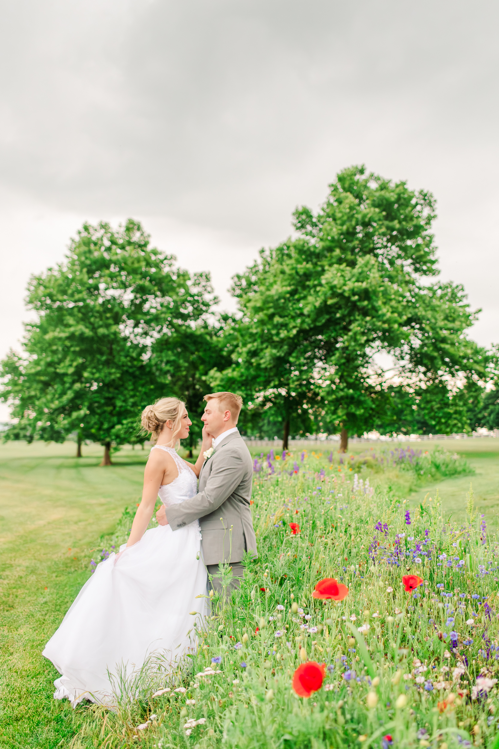 Bride and groom embracing in a colorful wildflower field at Bluebird Manor in Frederick Maryland
