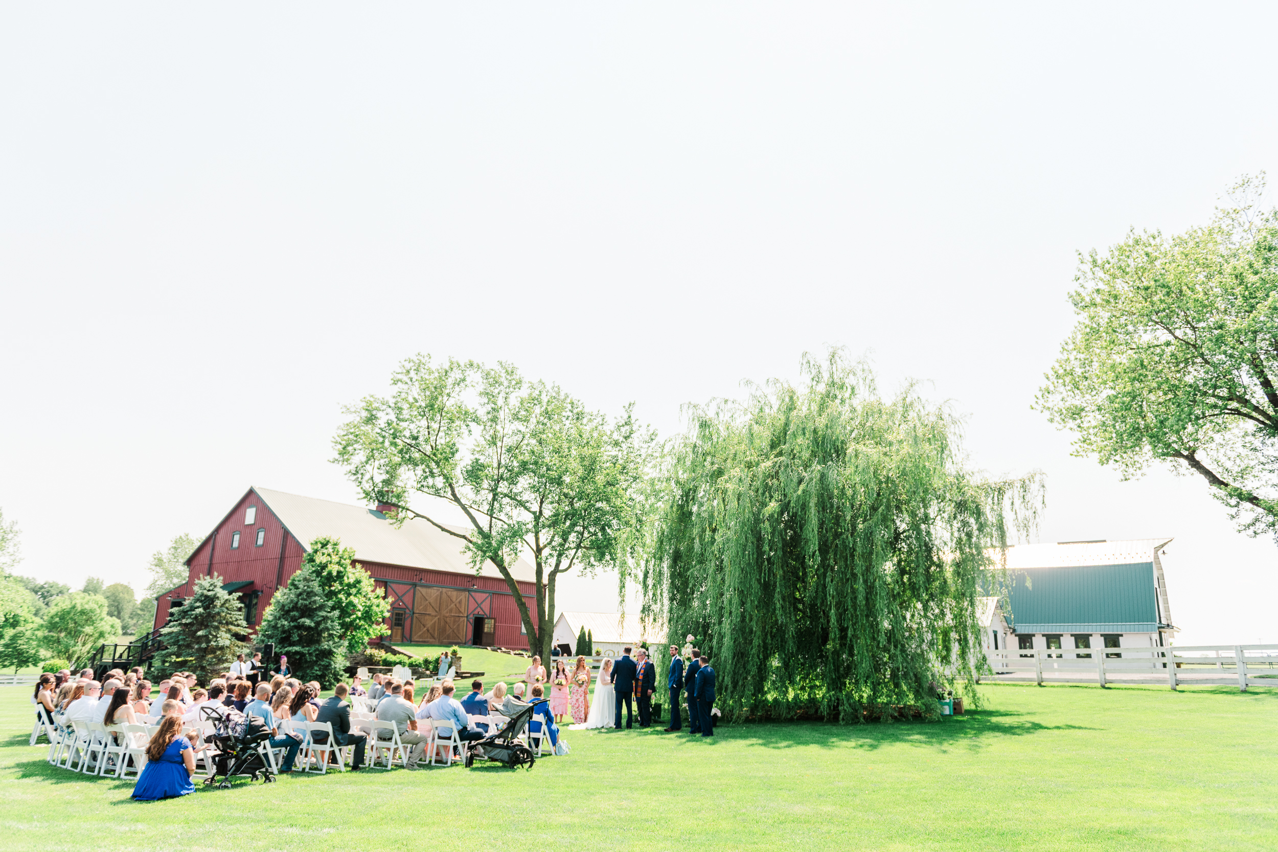 Outdoor wedding ceremony under willow tree at Bluebird Manor
