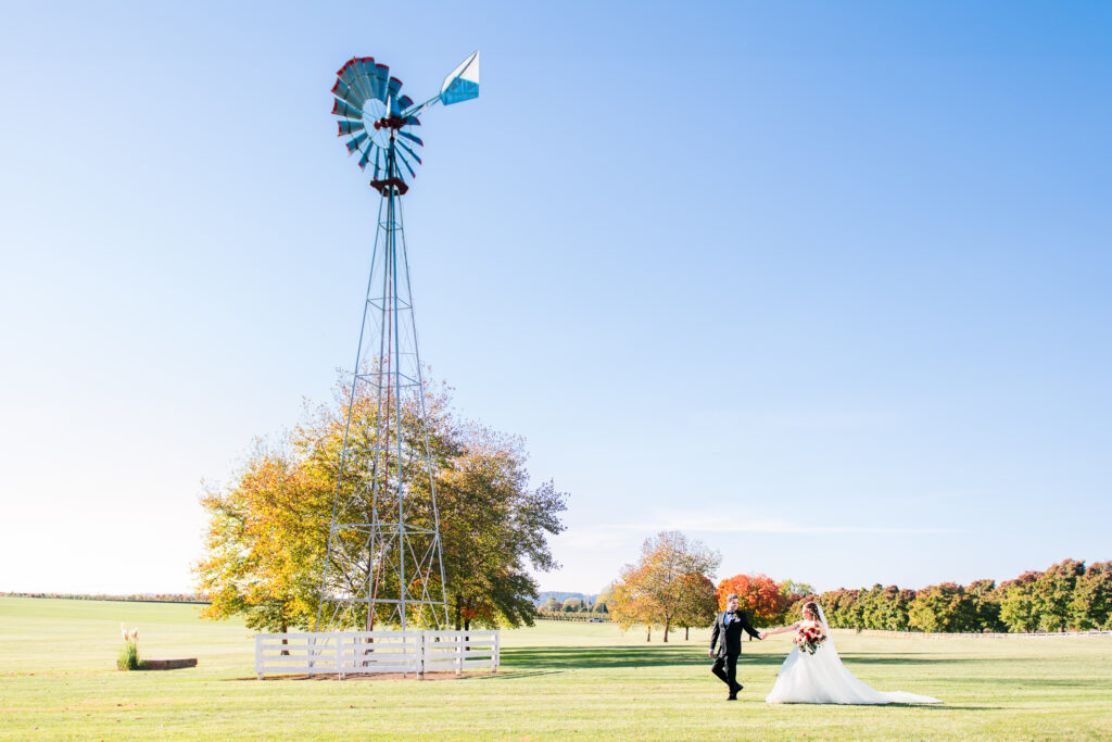 Groom leading bride with silo in the background